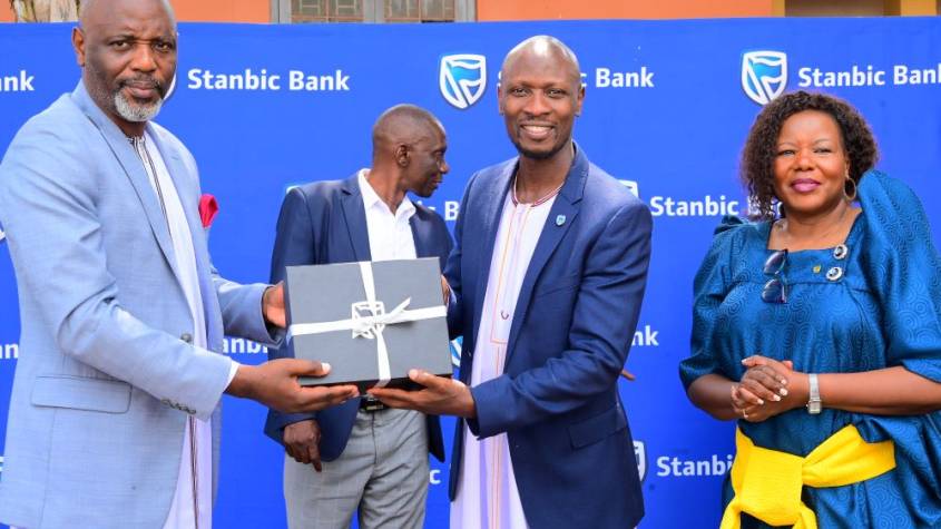 Stephen Segujja (R) Head, Economic Enterprise Restart Fund (EERF) and Cathering Poran, the CE Stanbic Business Incubator handing over a gift to the Rt. Hon. Joseph Muvawala the Prime Minister of Busog